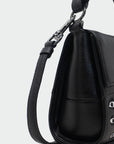 Black handbag with studded details on a light gray background