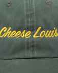Green cap with 'Cheese Louise' embroidered in yellow on a close-up view.