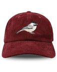 Maroon corduroy cap with embroidered bird design on a white background