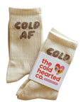 Beige socks with 'COLD AF' text and a branded label on a white background