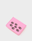 Pink cardholder with eye designs on a light gray background