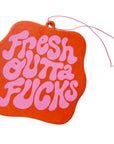 Orange air freshener with pink text on a white background