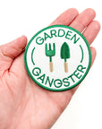 Circular patch with 'Garden Gangster' text and gardening tools held in a hand.