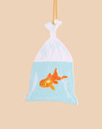 Plush toy of a goldfish in a bag on a beige background