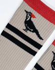 Sock with a woodpecker design and red, black, and beige colors on a white background