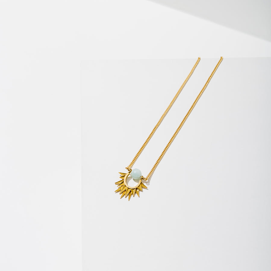 Larissa Loden Jewelry, Handmade in MN. Capri Necklace, Mini faceted gemstone wrapped around brass sun burst hangs from matte gold chain. Necklace 18 inches long with clasp.