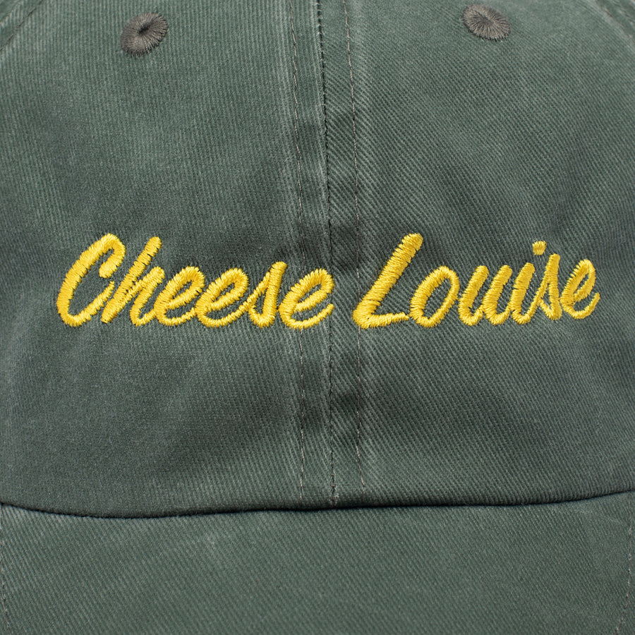 Green cap with 'Cheese Louise' embroidered in yellow on a close-up view.