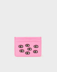 Pink cardholder with black eye designs on a light gray background