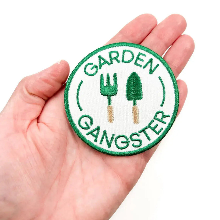 Circular patch with 'Garden Gangster' text and gardening tools held in a hand.