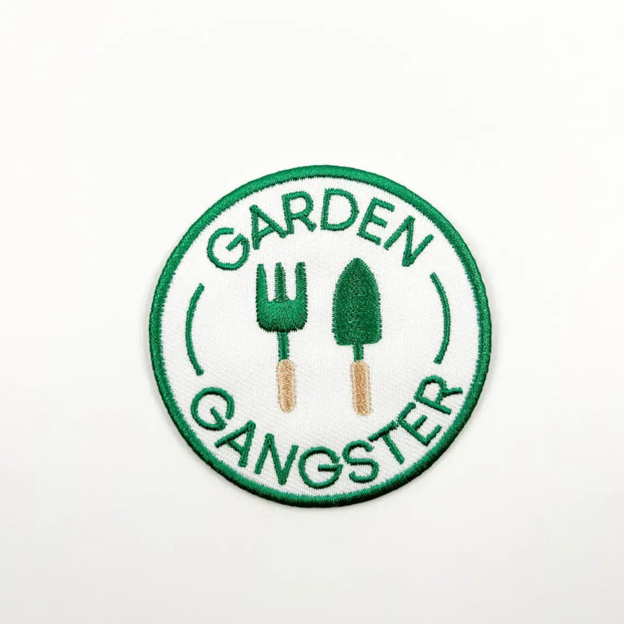 Circular patch with 'Garden Gangster' text and gardening tools on a white background