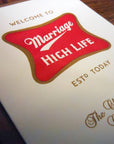 Card with 'Marriage High Life' design on a wooden surface