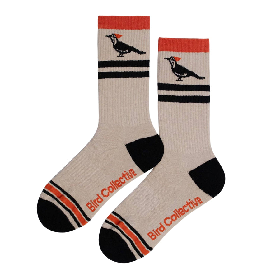 Beige socks with black and red accents and bird illustrations on a white background