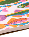 Notebook with colorful fish pattern on a white background
