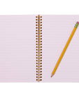 Open notebook with a spiral binding and a yellow pencil on a white background