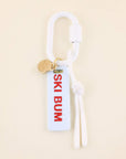 Keychain with 'Ski Bum' tag on a beige background