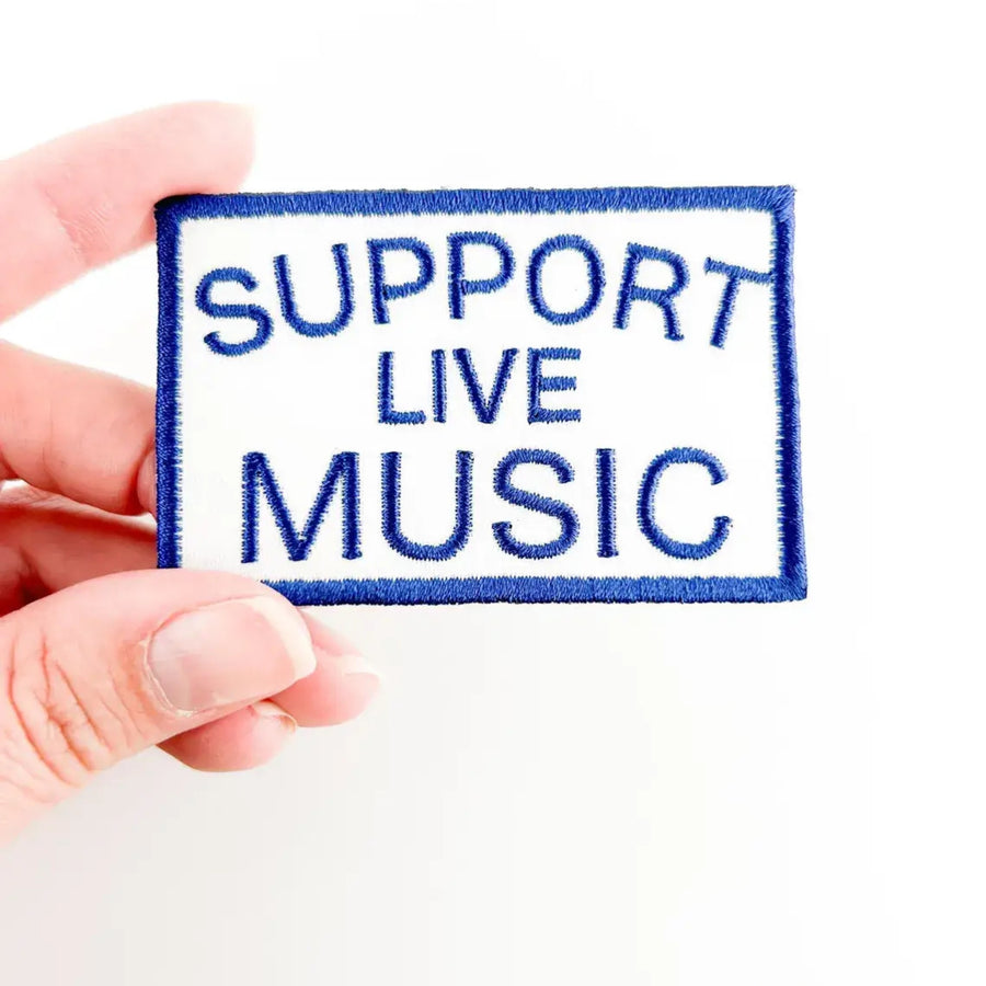 Patch with 'Support Live Music' text held by a hand on a white background