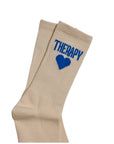 Beige socks with blue 'HEART' and 'THERAPY' text on a white background