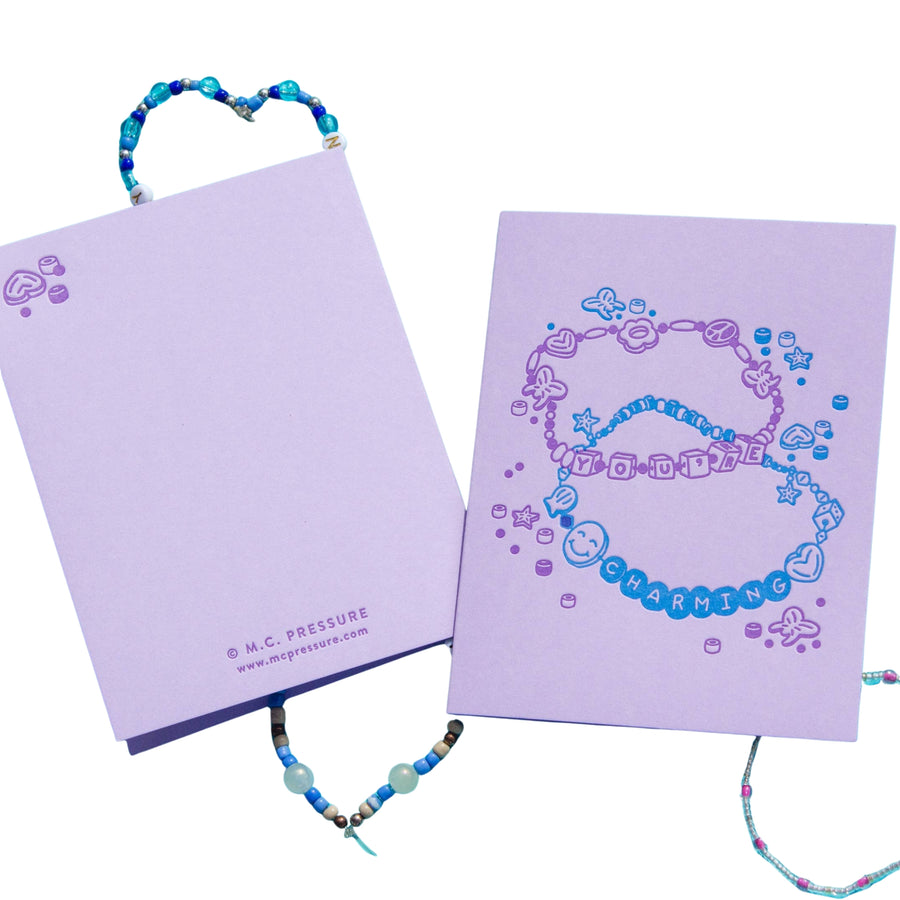 Two purple notebooks with jewelry designs on a white background