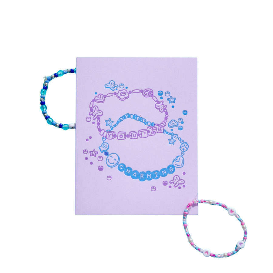 Colorful beaded bracelet on a purple card with 'GUARDING' text, against a white background