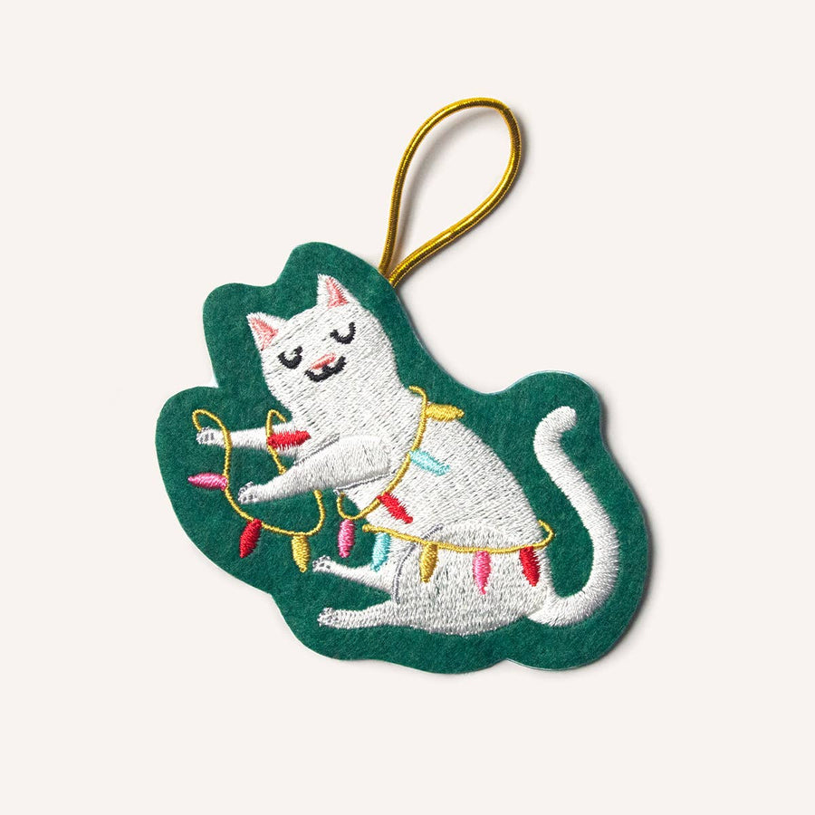 Embroidered cat ornament with Christmas lights on a green leaf-shaped background