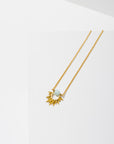 Larissa Loden Jewelry, Handmade in MN. Capri Necklace, Mini faceted gemstone wrapped around brass sun burst hangs from matte gold chain. Necklace 18 inches long with clasp.
