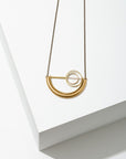 Larissa Loden Jewelry, Handmade in MN. Alden Necklace, Brass concentric circles suspended in a half circle shape on antiqued brass chain. Necklace is 30 inches long with a clasp.