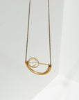 Larissa Loden Jewelry, Handmade in MN. Alden Necklace, Brass concentric circles suspended in a half circle shape on antiqued brass chain. Necklace is 30 inches long with a clasp.